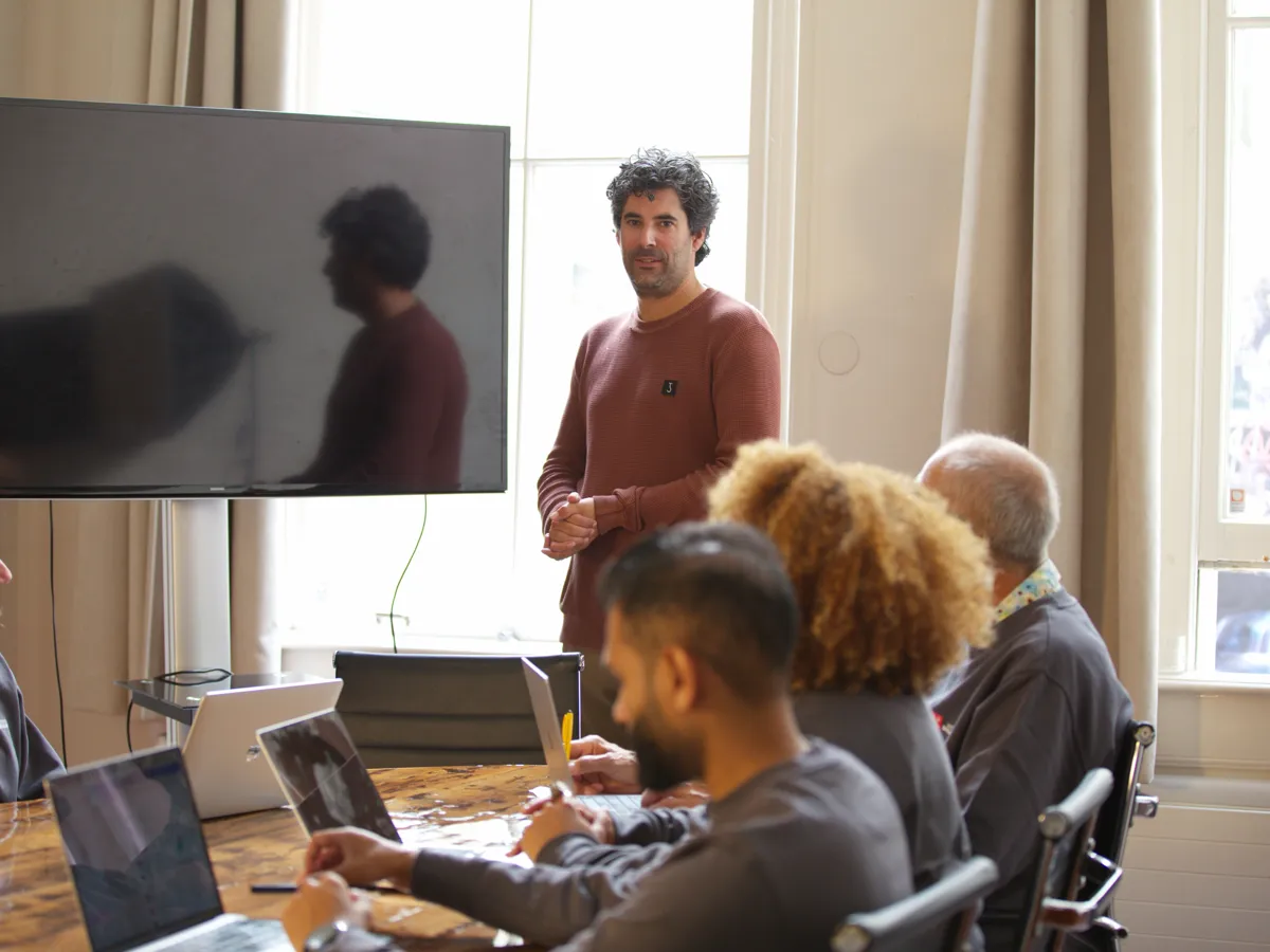 Participants work on their own laptops while the teacher explains