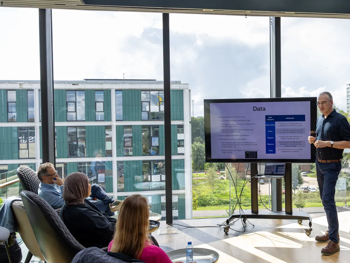 A teacher presents to a group in a classroom overlooking Science Park