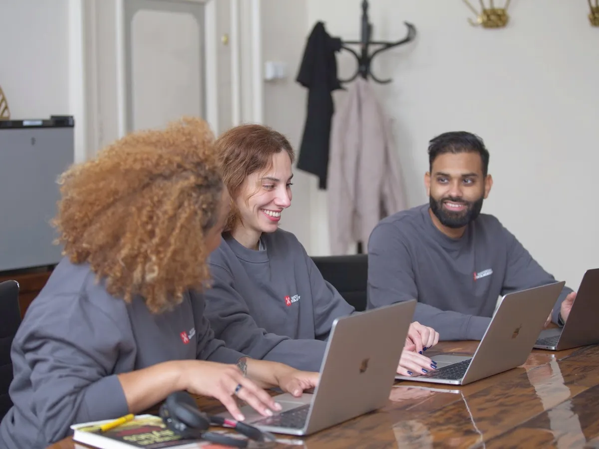 Drie collega's die samen aan hun laptop werken